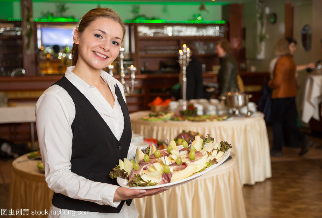 餐饮服务雇员或女服务生与一盘开胃菜